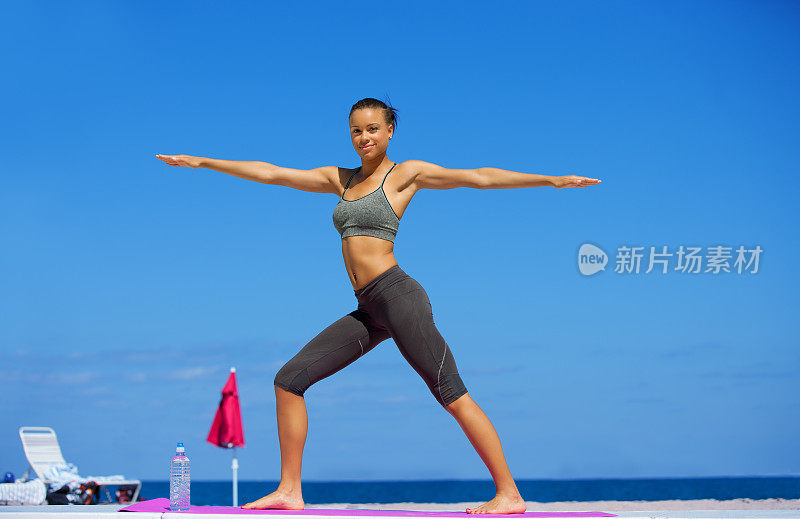 年轻女子在海滩上做瑜伽运动