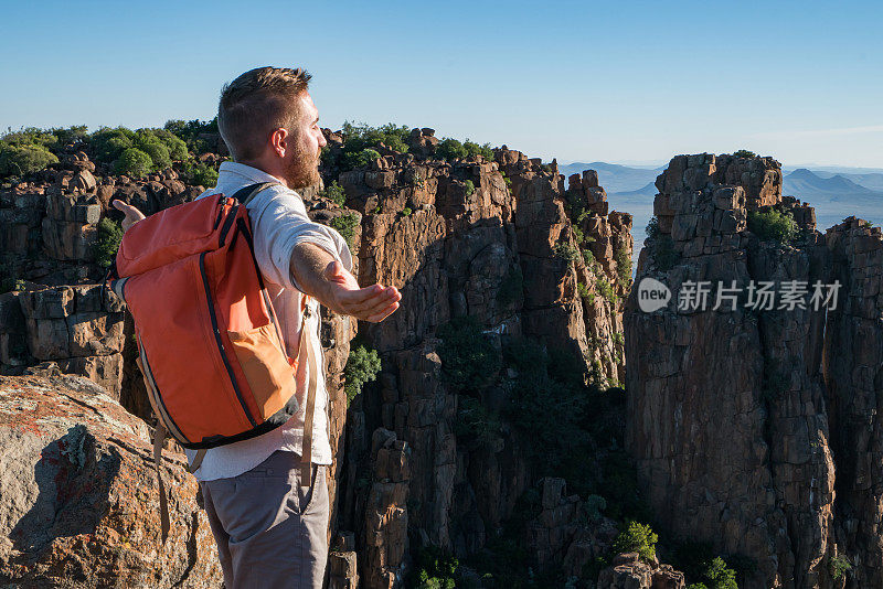 年轻人在山顶上张开双臂