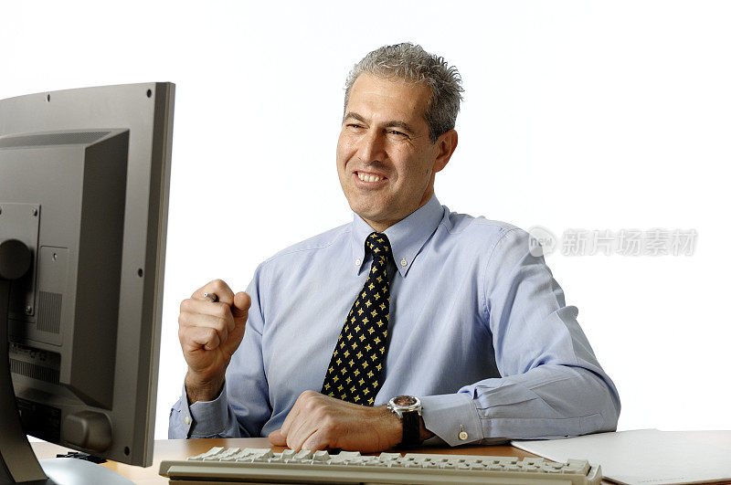 笑容可人的商人坐在显示器前的办公桌前