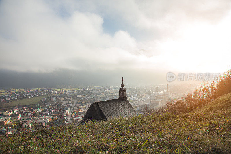 从山上俯瞰城市全景，前景是一个教堂的屋顶