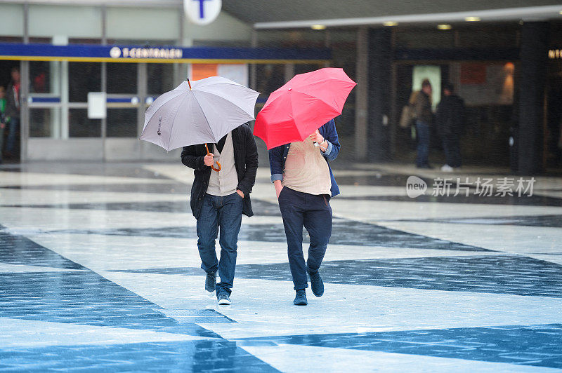 行人和雨伞在大风中