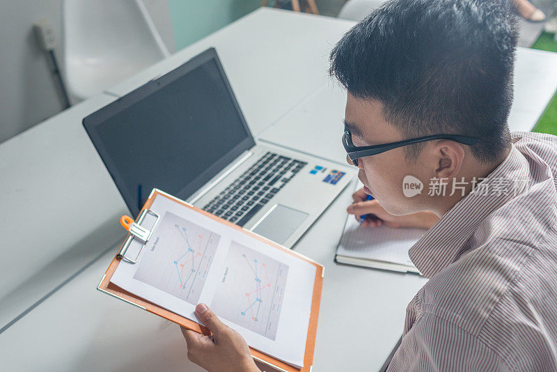 年轻的亚洲人在为他的老板做月度报告