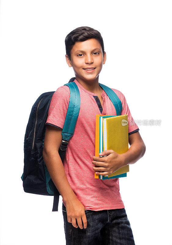 一个十几岁的男生拿着书，面带微笑地站着