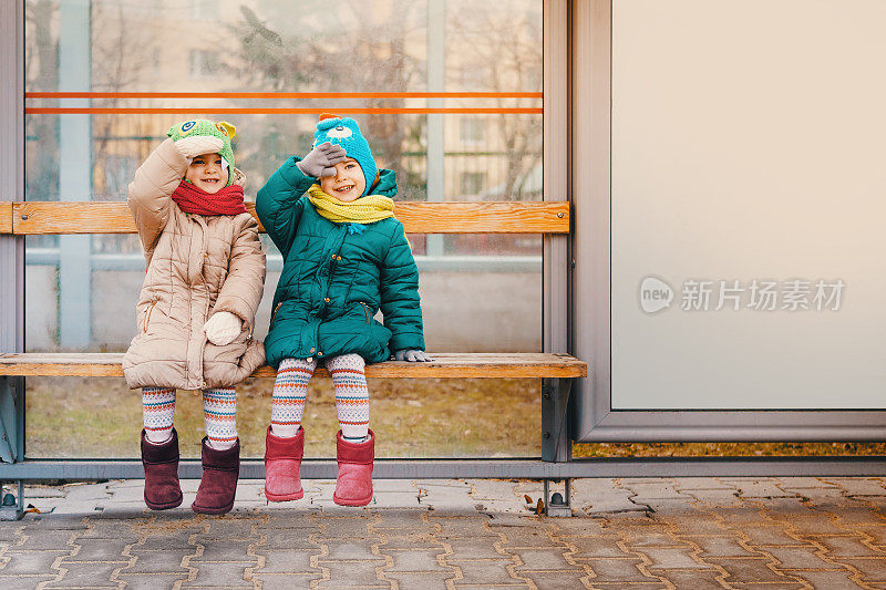 两个女孩坐在公共汽车站