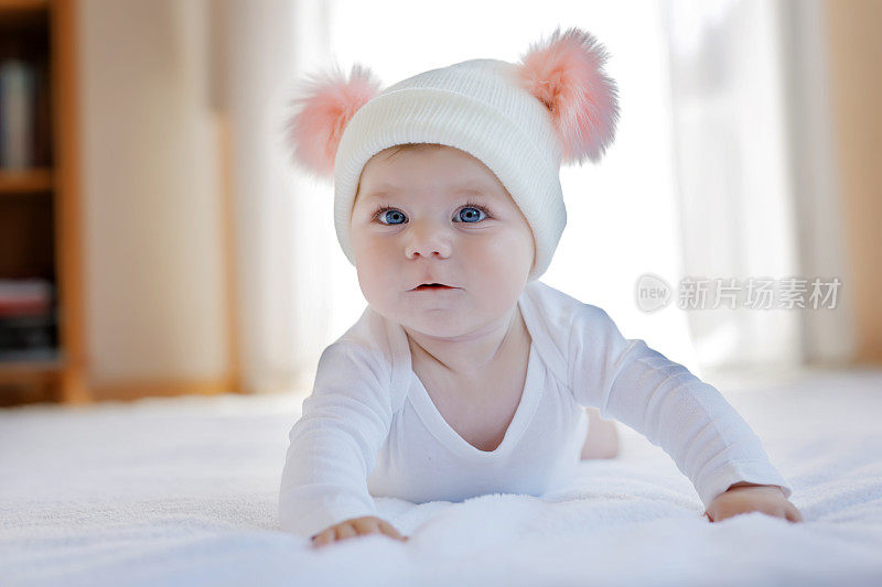 可爱可爱的宝宝和温暖的白色和粉红色的帽子和可爱的球