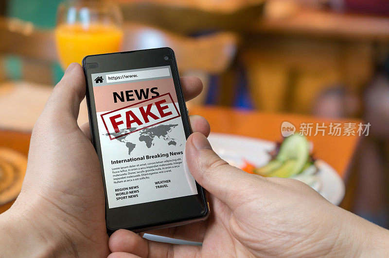 男人拿着智能手机在网上看假新闻。宣传、虚假信息和骗局的概念。
