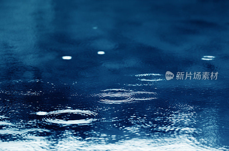 雨的背景与雨滴，圆圈和水泡在水坑