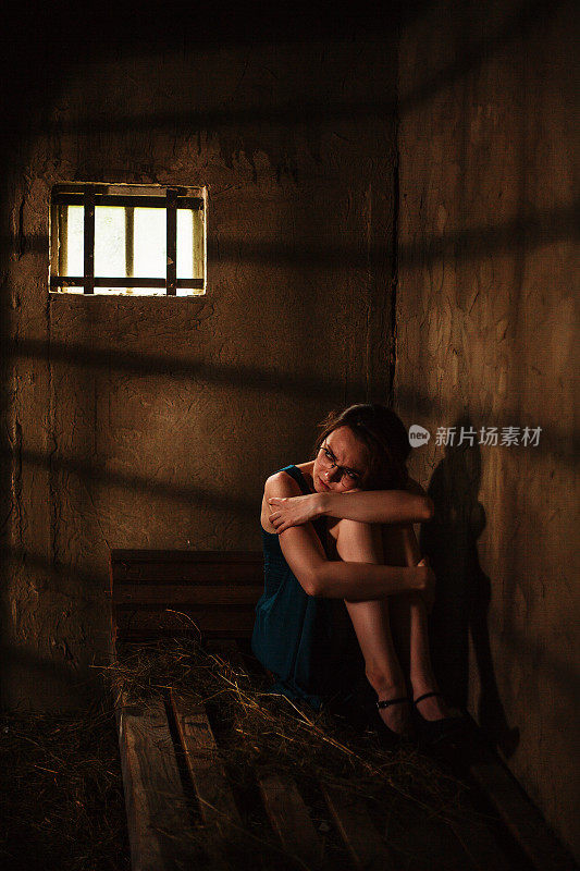 在黑暗的监狱里被吓坏的年轻女人
