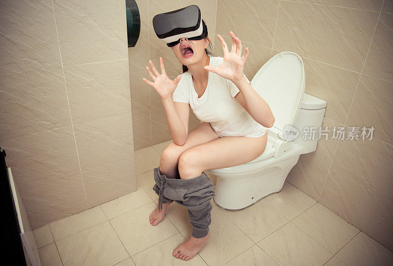 迷人的震惊女孩坐在厕所马桶上