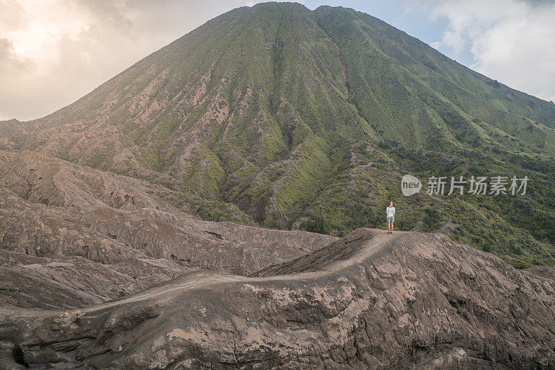 年轻女子徒步旅行沉思火山景观从火山口小径看布罗莫火山-人们旅行冒险的概念