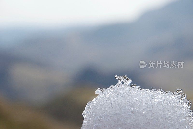 雪球中的冰晶;模糊的山在失焦背景