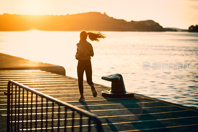 日落时分在海边跑步的女人