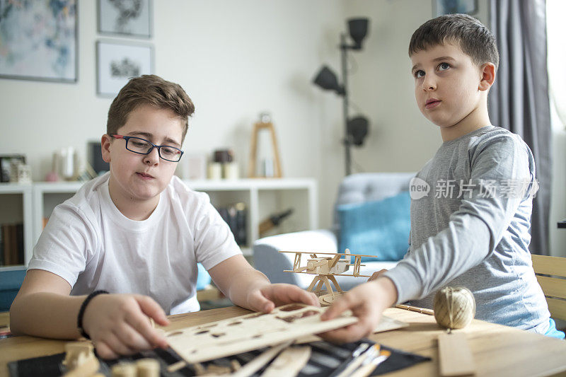 兄弟们正在为学校项目制作木制模型飞机