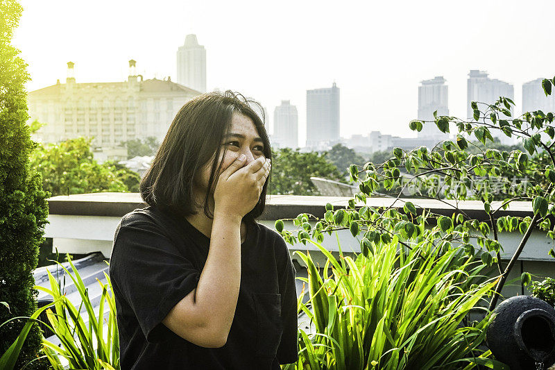 一个女人正用手捂住鼻子