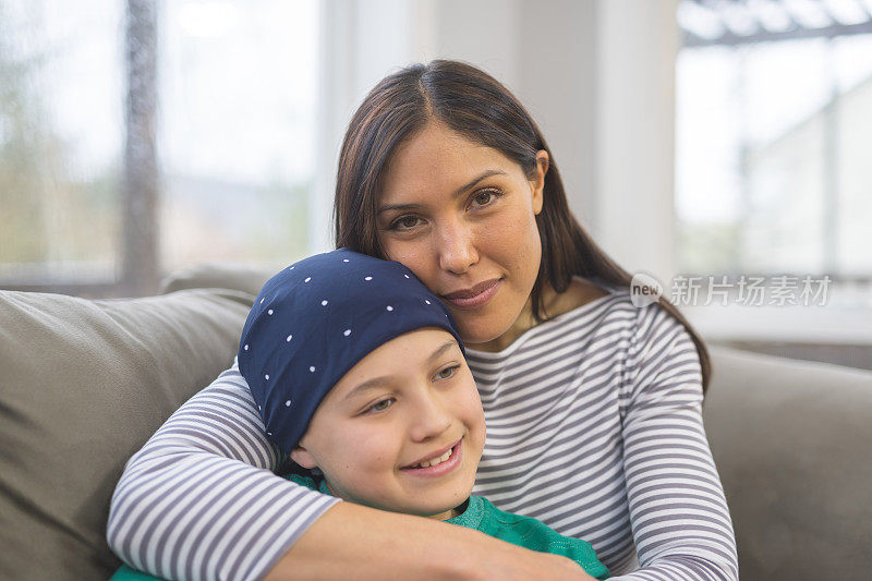 一个小男孩与癌症抗争的照片，他的妈妈拥抱着他