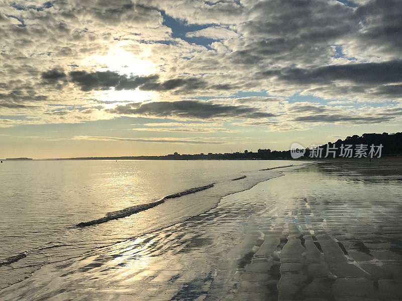 英国清晨海滩日出的图片，温和的海浪和潮汐拍打海岸，潮湿的沙子re云和粉红色的蓝天，伯恩茅斯海滩日出日落的照片，多塞特海岸线，英国西南部