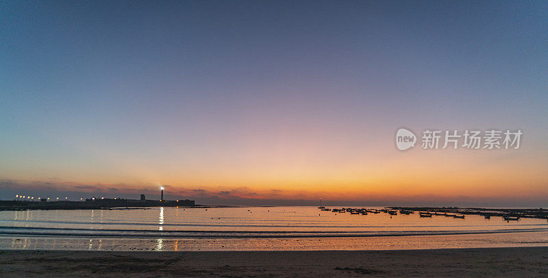 西班牙安达卢西亚，加的斯，拉卡莱塔海滩上的日落灯塔
