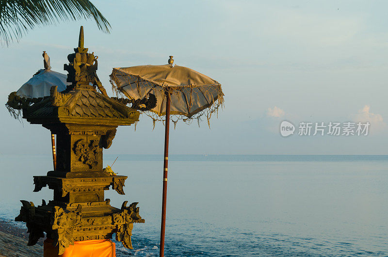 日出时巴厘岛海滩上的小印度教祭坛或神龛