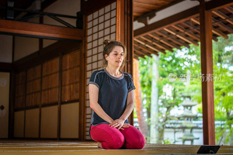 白人女性喜欢在寺庙里用智能手机练瑜伽