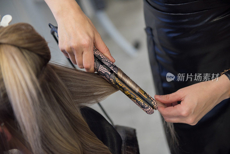 理发师用直发器给顾客拉直头发