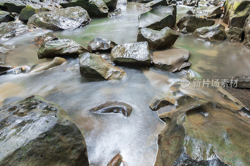 特写的水流过卵石的小溪