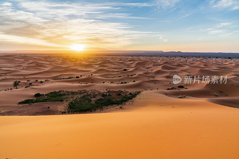 摩洛哥Merzouga沙漠的橙色沙丘和多云的天空。