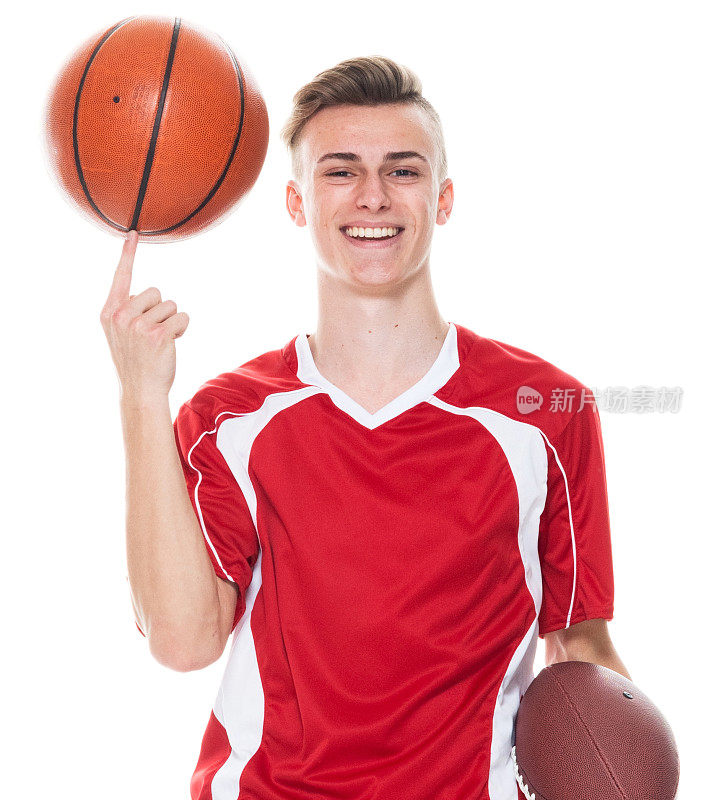 白人少年篮球运动员站在前面的白色背景穿着足球制服和抱篮球和踢足球运动和使用运动球