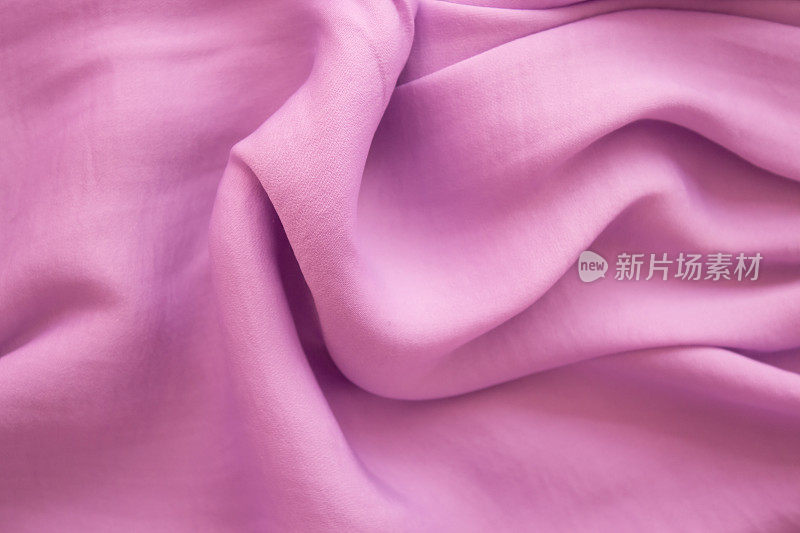 紫色柔软的织物在轻折叠布局与太阳高光和阴影。夏季概念，女性化的趋势，flatlay