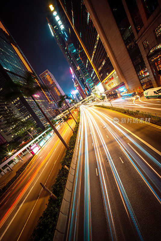 霓虹夜路，高速公路，高速交通穿过摩天大楼的城市景观香港