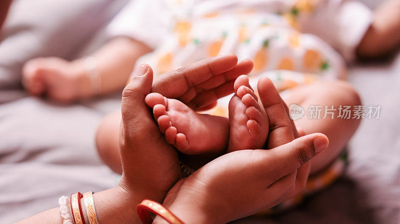 靠近妈妈，她手里拿着婴儿的脚