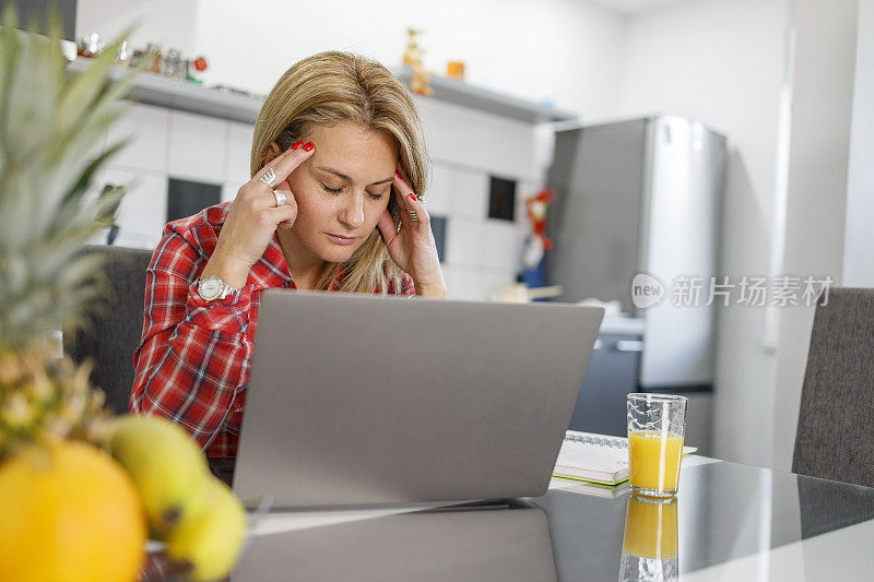 紧张的女商人用手提电脑双手抱头