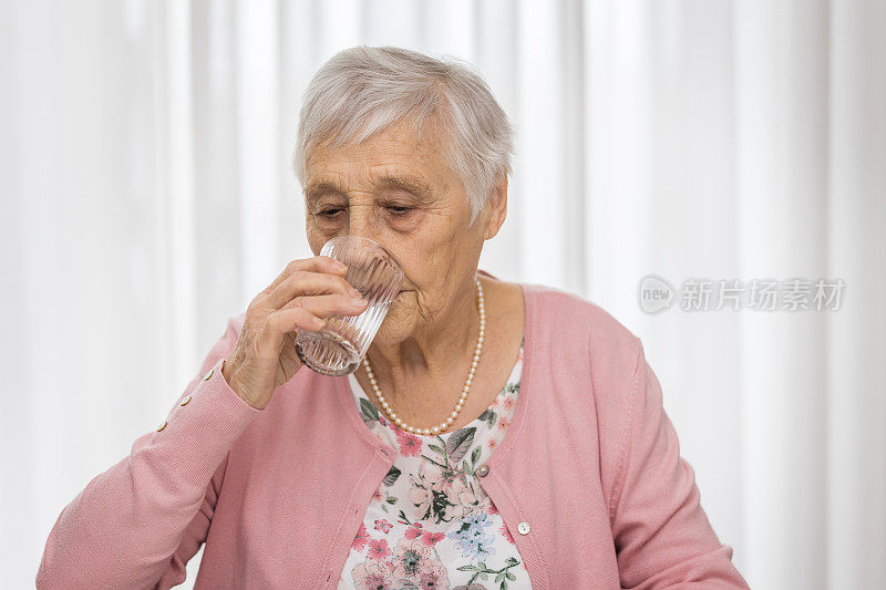 老女人在家喝一杯水