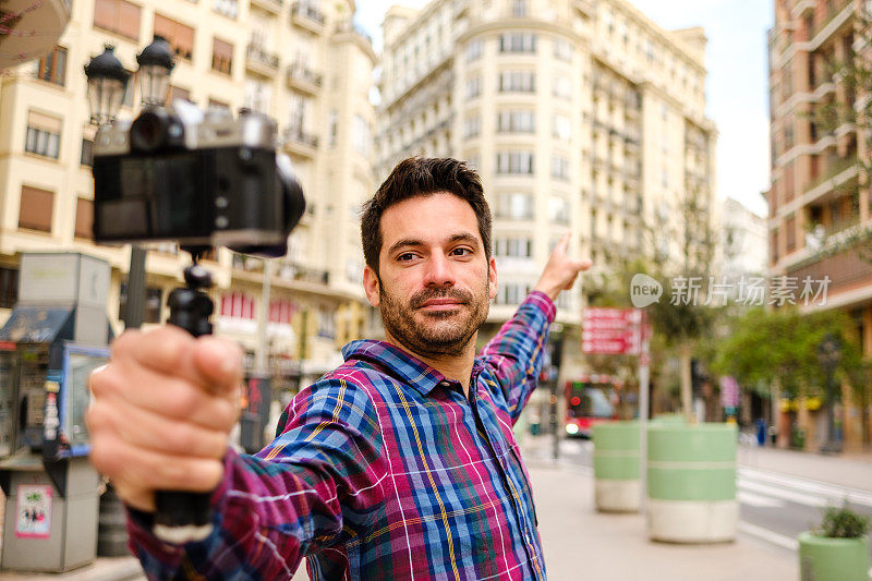 在一座城市里，一名男子用摄像机拍摄一段视频