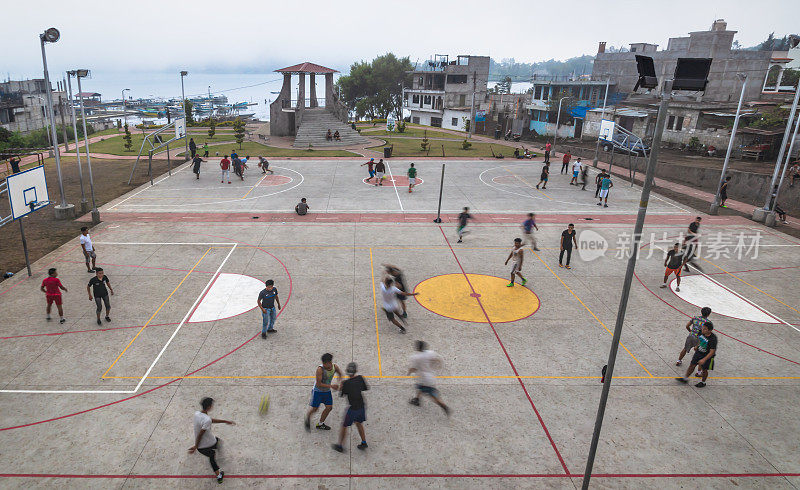 危地马拉，圣地亚哥阿提特兰，当地男子在湖边的操场上踢足球和打篮球