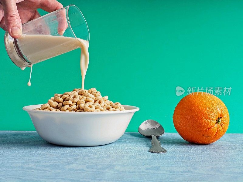 把牛奶倒在健康的燕麦粥上，把整个橙子放在旁边