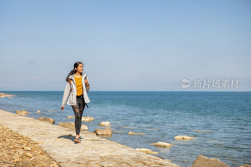 年轻的成年印度妇女在海边散步