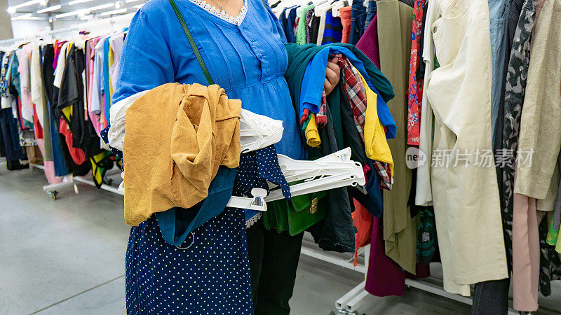 一位40-45岁的年轻女子在二手商店买衣服