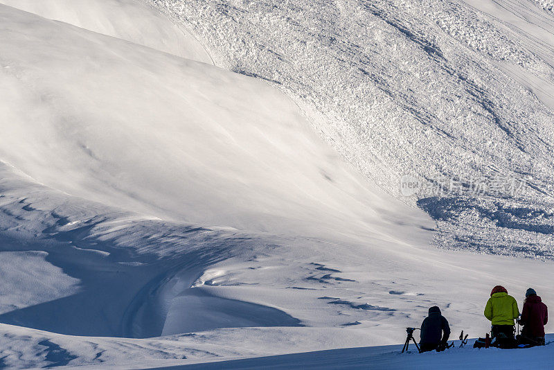 偏远地区的滑雪者在多雪的山脊上休息