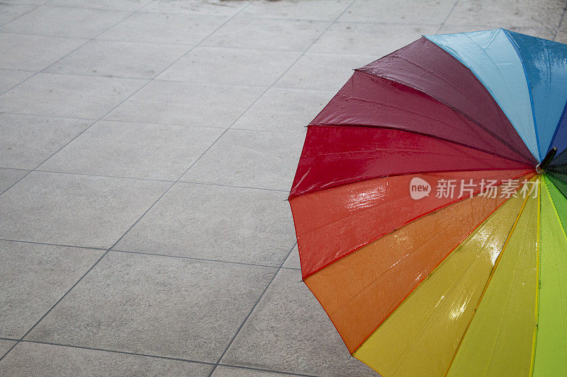 雨点落在彩虹伞上，天以自然为背景