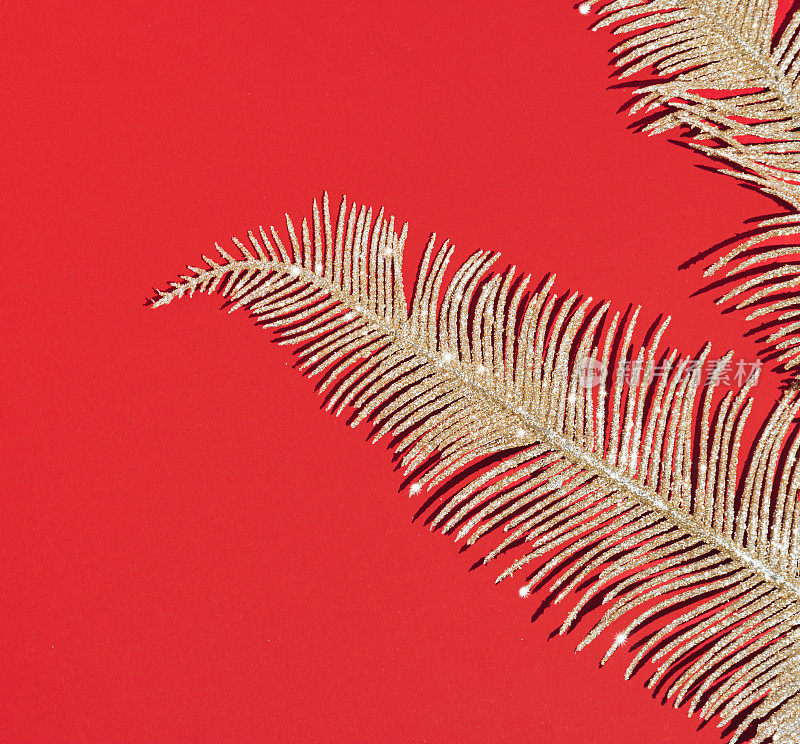 在圣诞节红色的背景上，金光闪闪的镯子。抽象的假日壁纸。剥躺的概念。