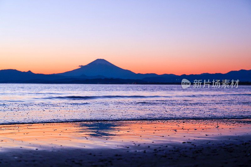 夕阳下，沙滩上的富士山轮廓