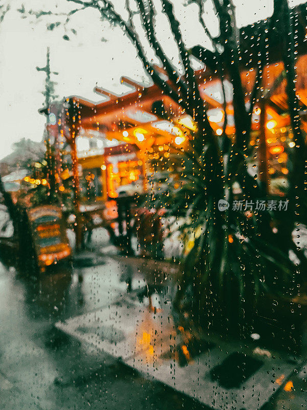 下雨天从一家咖啡馆的窗户看到俄勒冈州波特兰市酒吧的天井灯流行病