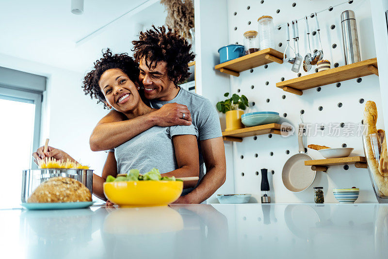 笑着的黑人夫妇在厨房准备沙拉