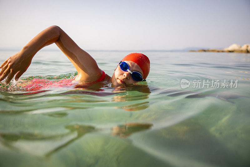 白种年轻女子在海里游泳