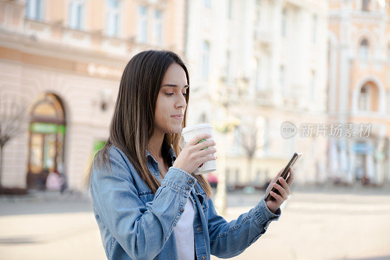 快乐的年轻女子正在使用她的智能手机