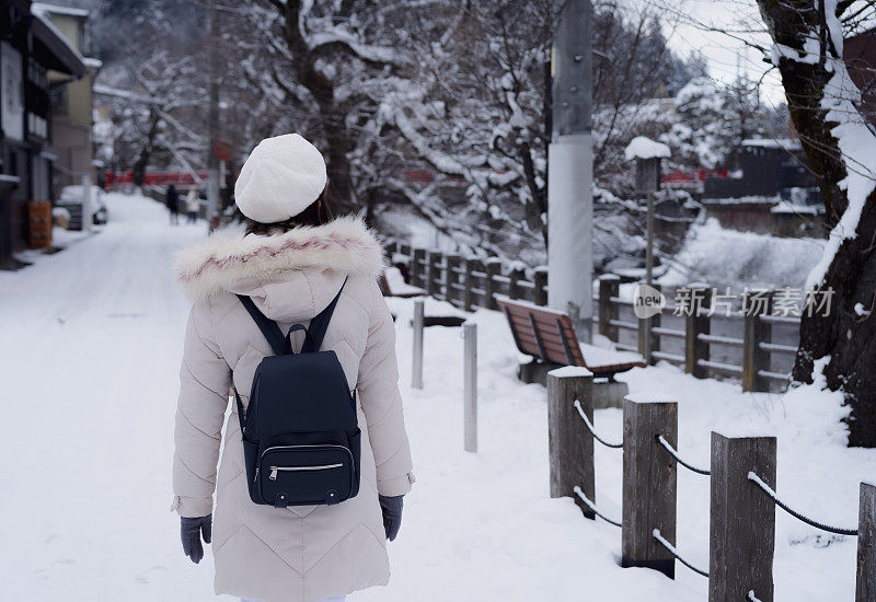 美丽的女子游客享受他们的日本之旅在雪的冬天。