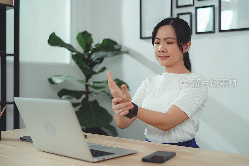 亚洲女性在家办公时手痛。