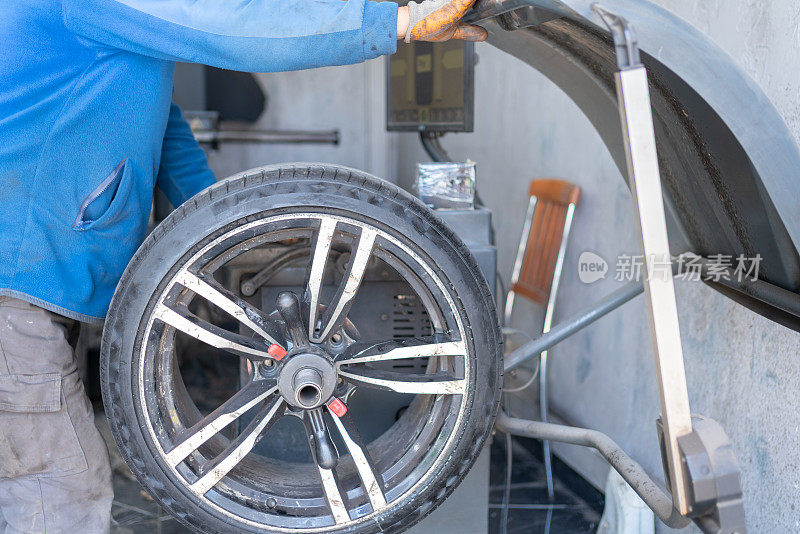 男子平衡轮胎在汽车修理店