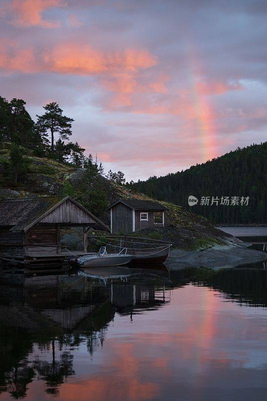 日落时湖岸上垂直的木屋