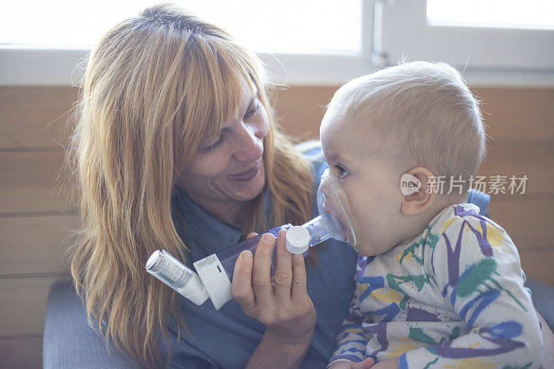 妈妈帮助她的孩子吸入治疗哮喘的药物